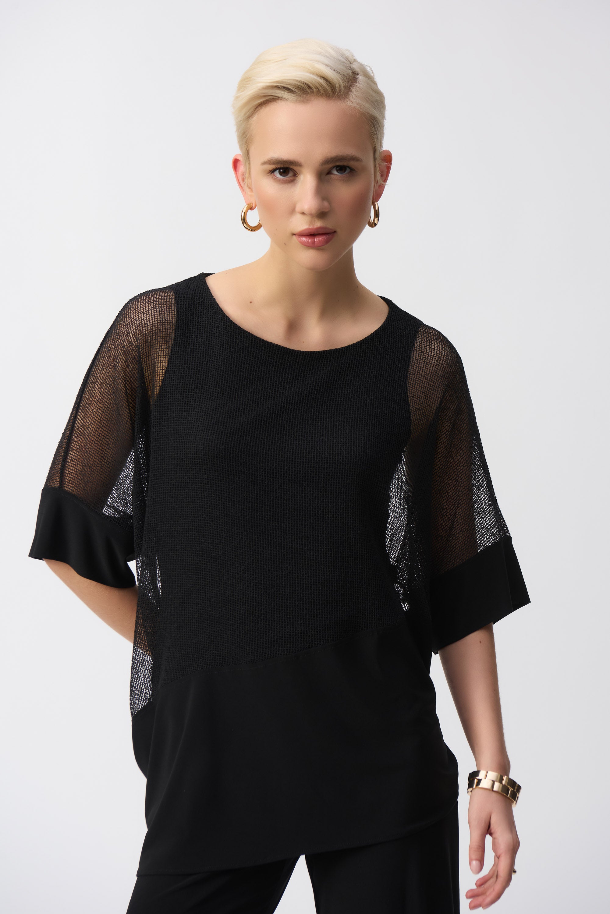 Close-up front view of the black mesh cocoon top, highlighting the sheer dolman sleeves and silky knit panel.