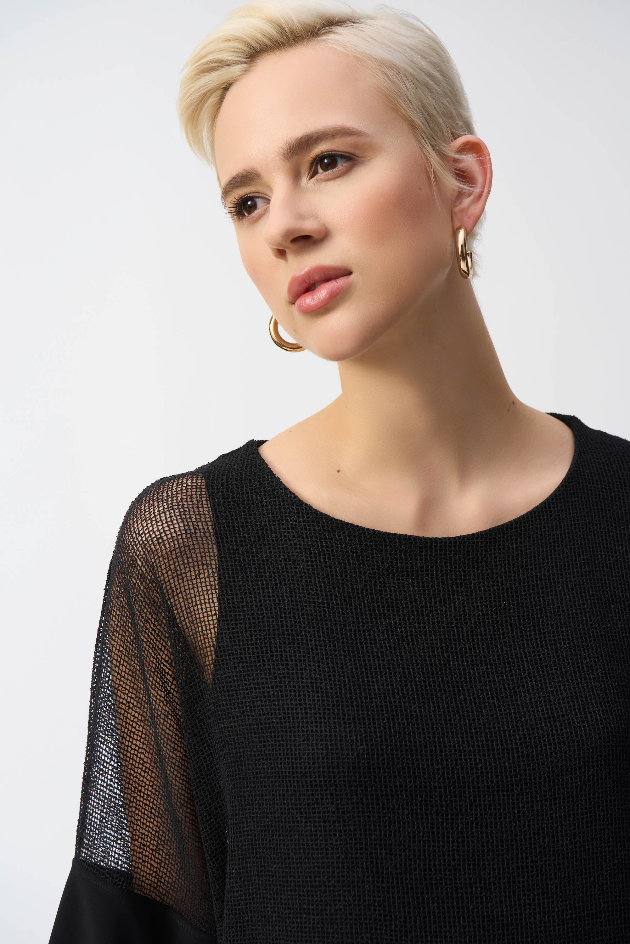 Detail of the black mesh fabric on the shoulder and neckline of the top.