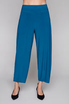Blue lantern leg pants worn by a person on a white background