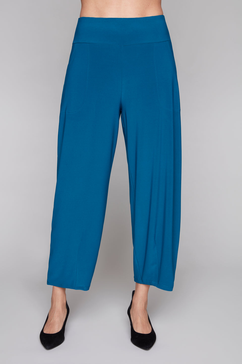 Blue lantern leg pants worn by a person on a white background