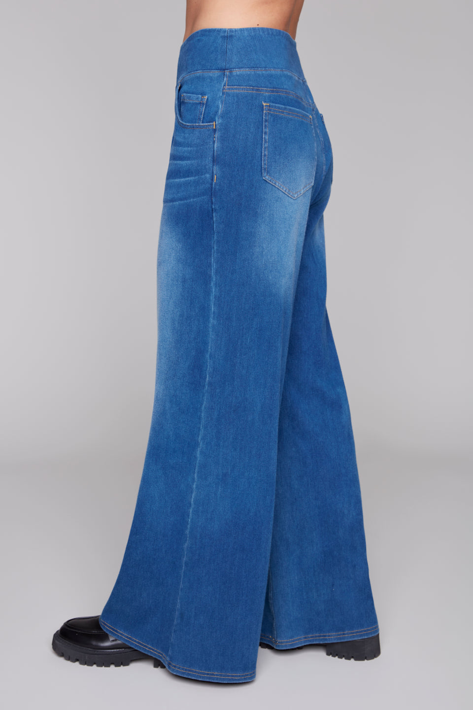 Side View of Blue denim wide-leg jeans on a plain background