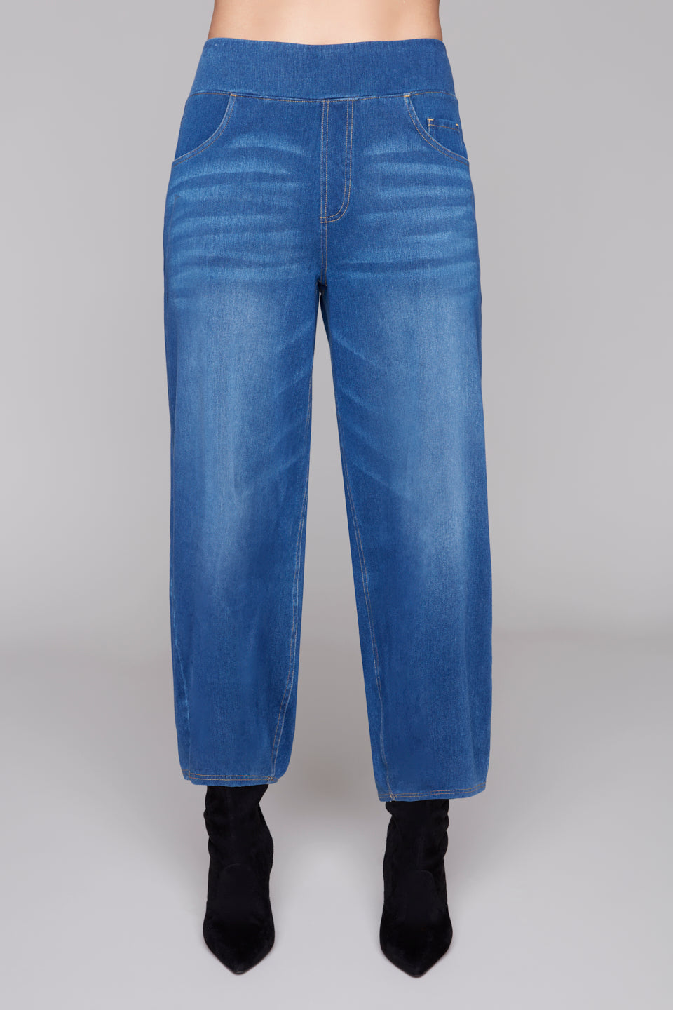 Blue jeans worn by a person on a gray background