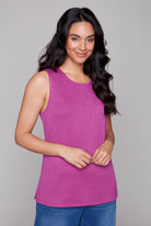 Woman wearing a purple sleeveless top against a gray background