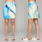 Front and side view of woman in blue abstract skort and sandals