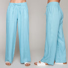 Woman wearing blue wide-leg linen pants with drawstring waist and white sandals