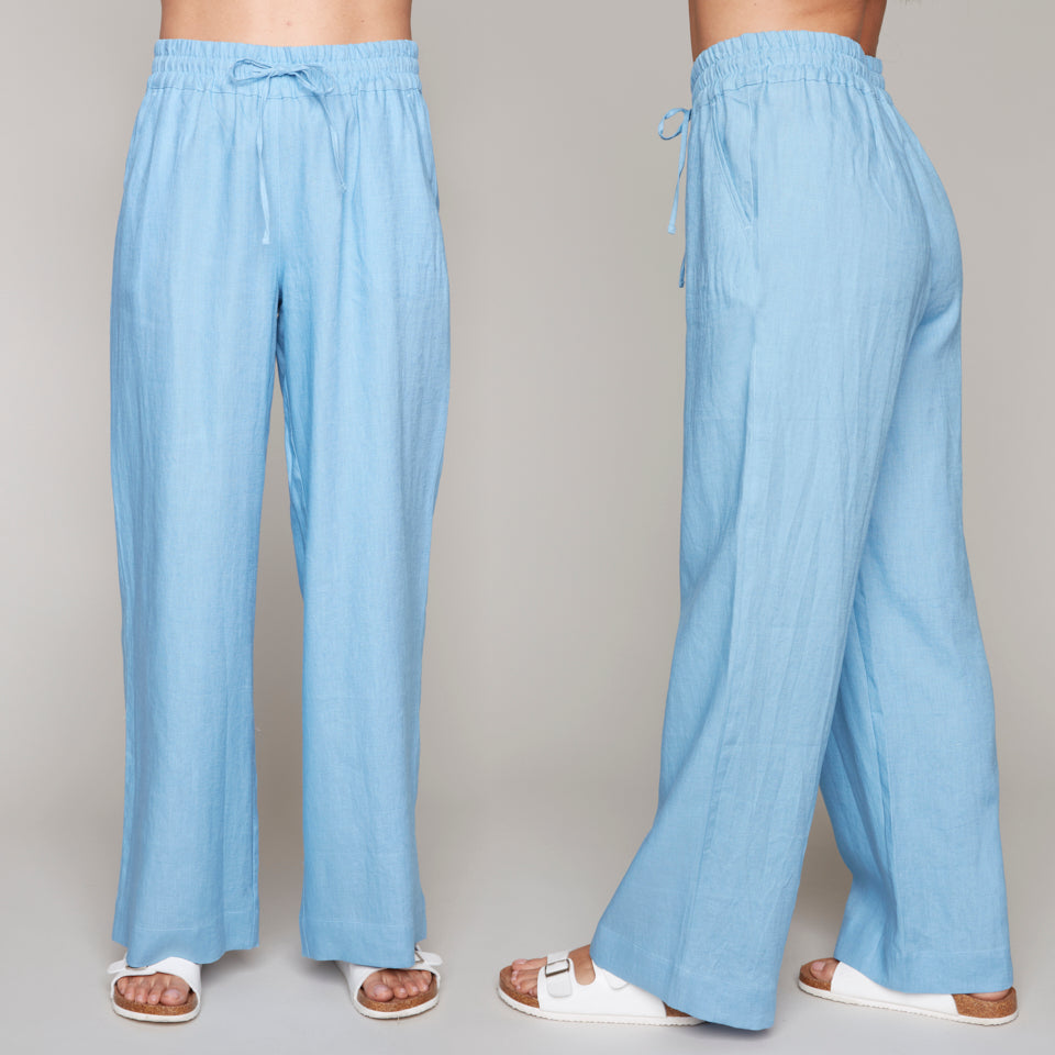 Woman modeling pale blue wide-leg pants with elastic waistband and drawstring