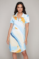 Woman wearing short sleeve knit dress in blue and yellow abstract print with zip collar