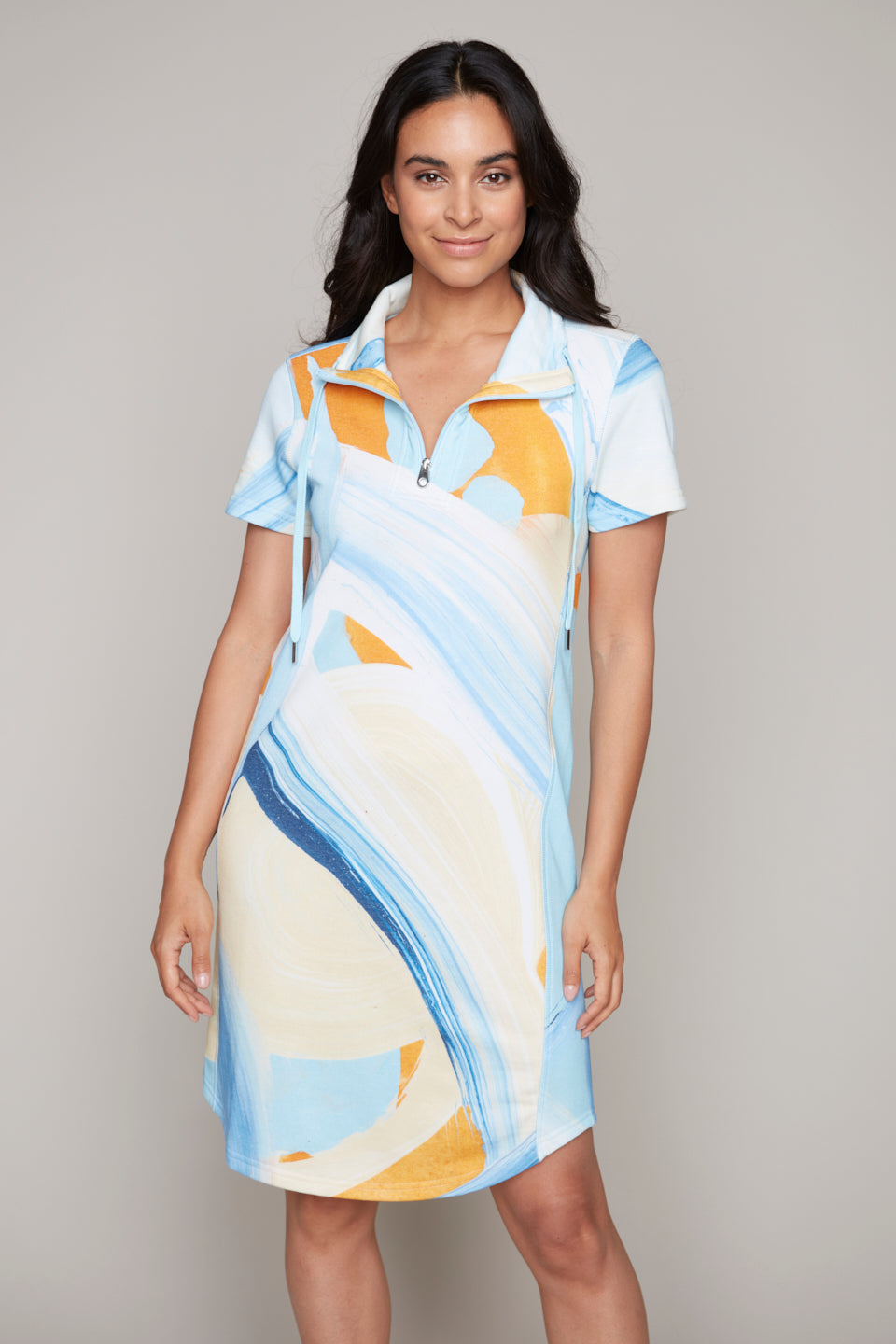 Woman wearing short sleeve knit dress in blue and yellow abstract print with zip collar