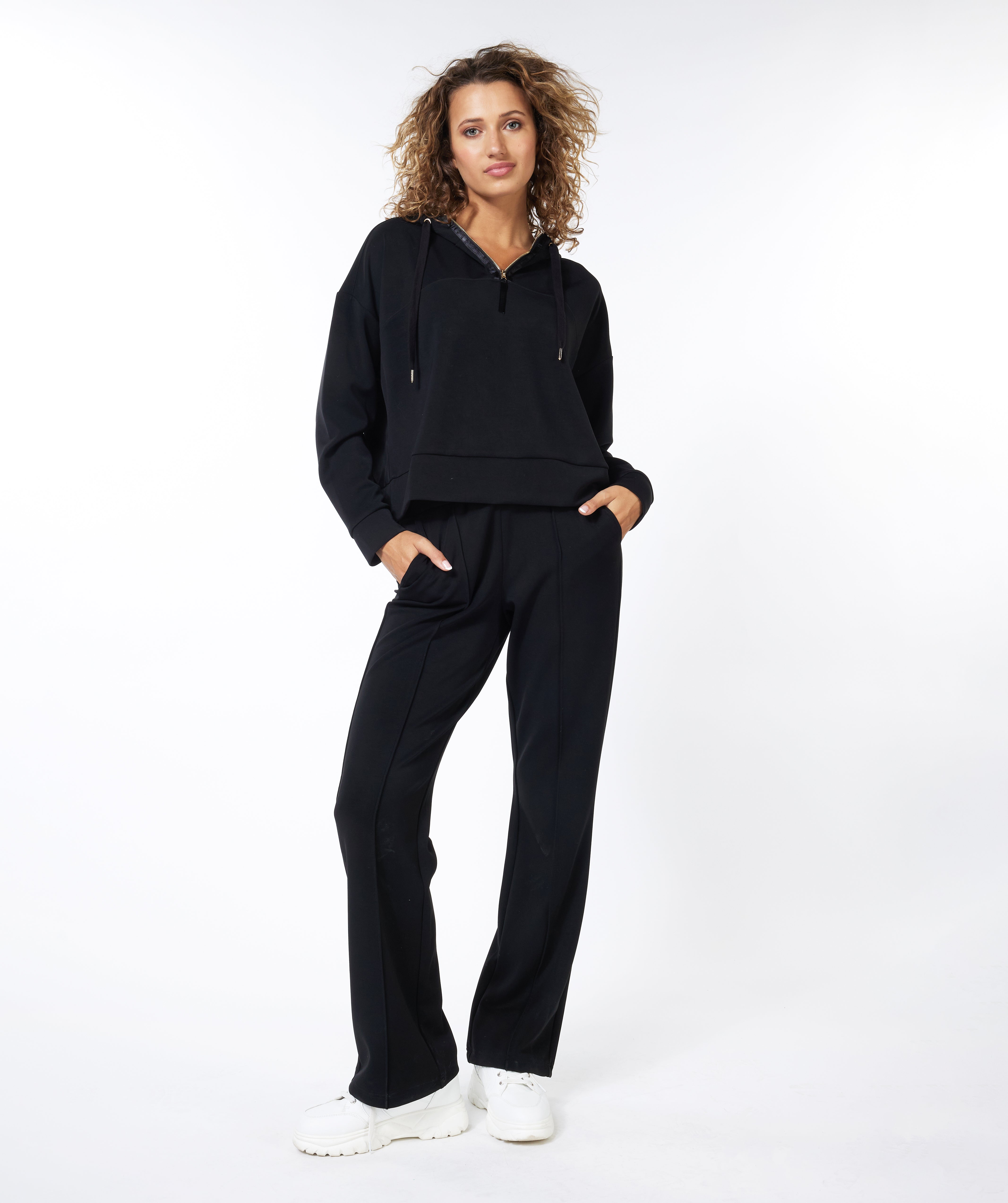 Woman wearing a black tracksuit on a white background