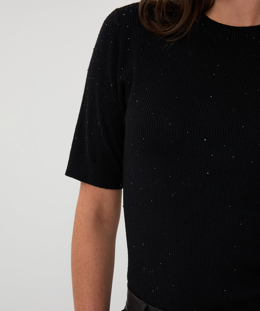 Black short-sleeve top with speckled pattern on a plain background