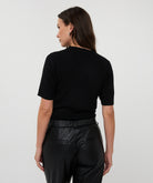 Back View of Person wearing a black top and black pants on a white background