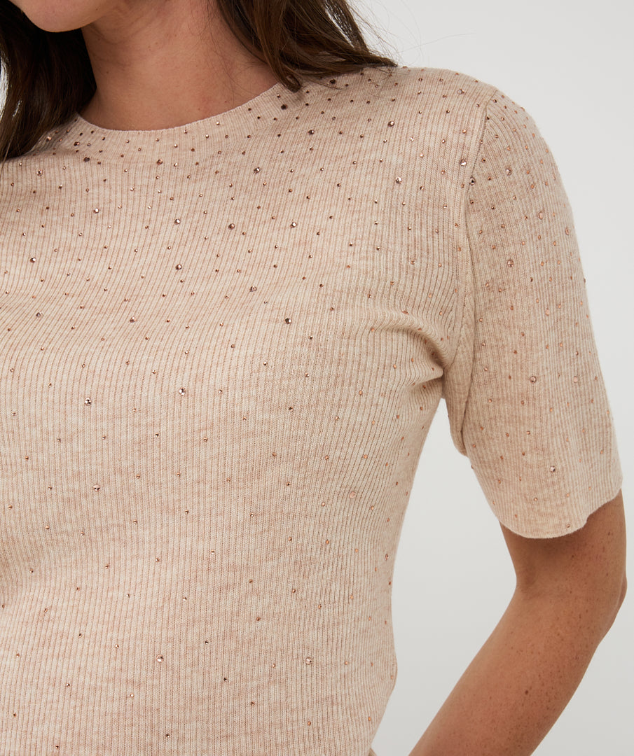 Close Up of Beige ribbed sweater worn by a person on a white background