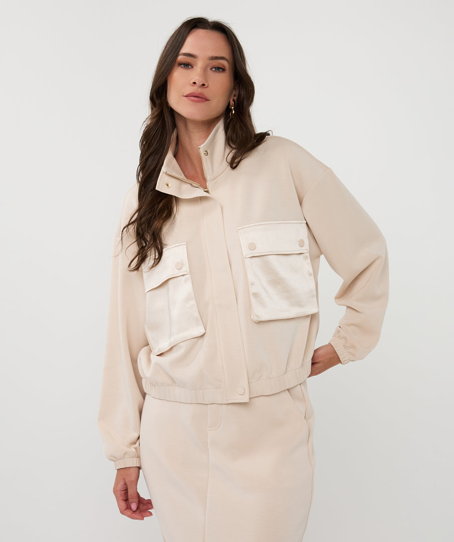 Woman wearing a beige jacket and pants on a white background