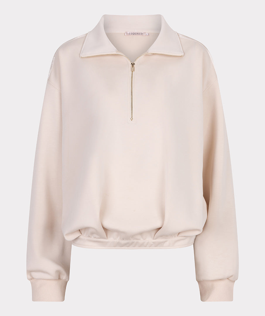 Beige sweatshirt with a zipper on a light gray background