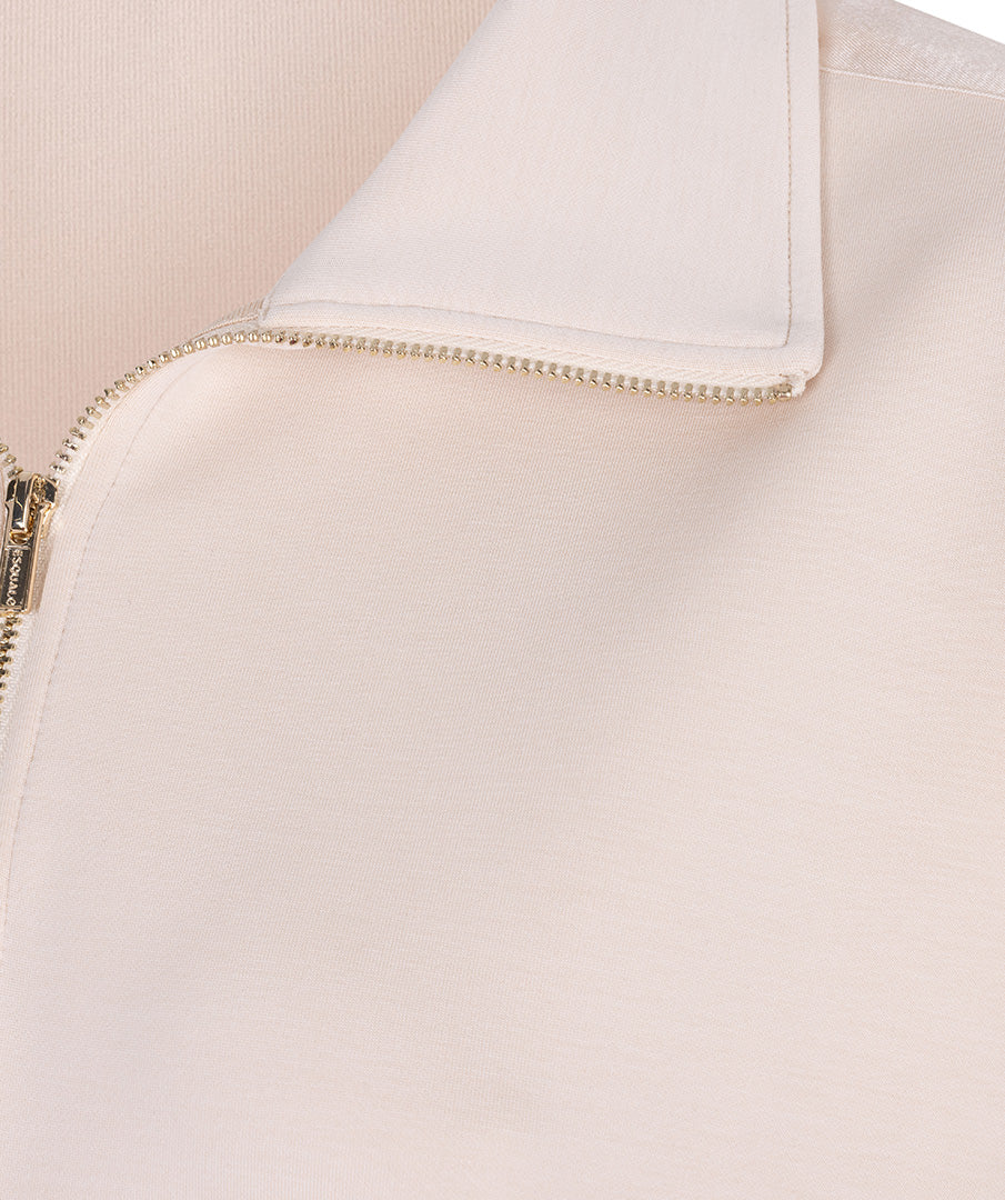 Close-up of a beige jacket with a zipper detail