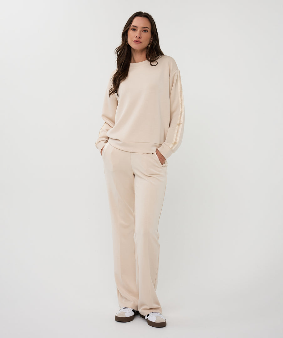 Woman wearing a beige model outfit on a white background