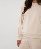 Beige sweatshirt worn by a person on a white background