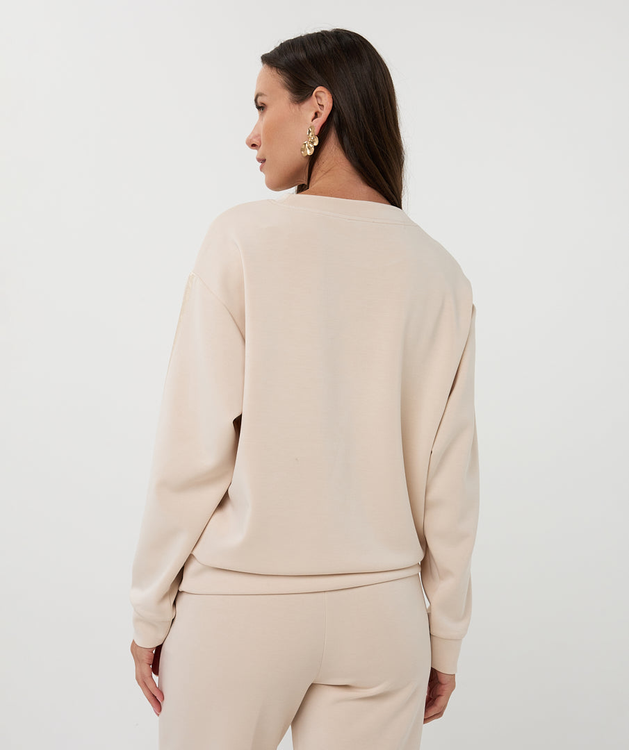Back View of Woman wearing a beige outfit against a white background