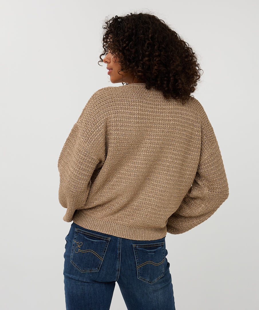 Back View of Person wearing a beige knitted sweater and blue jeans on a white background
