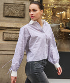 Woman wearing a striped shirt and jeans walking outdoors.
