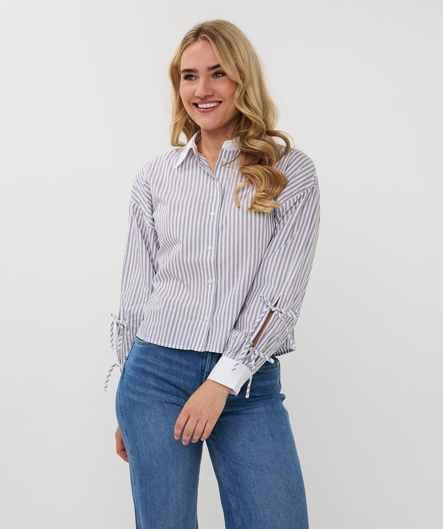 Close up of Woman wearing a striped shirt and blue jeans on a white background