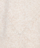 Close-up of a textured beige fabric with a diamond pattern