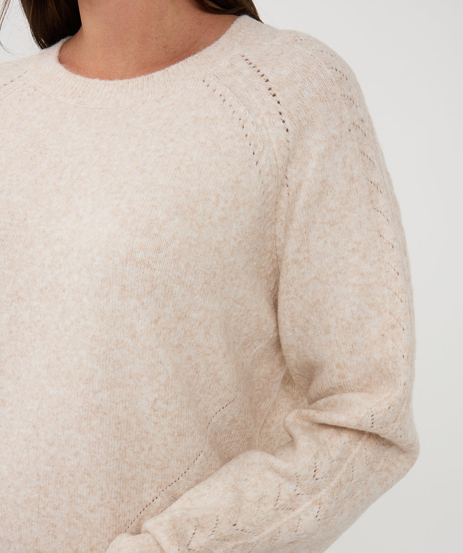 Close-up of a beige sweater on a white background