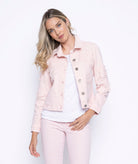 Woman wearing a cropped light pink denim jacket with tonal embroidered flowers on the chest and sleeves, paired with matching pink jeans and a white textured top.