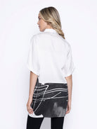 Back view of oversized white and black shirt showing the graphic print continuing around the hemline.