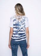 Woman wearing white short sleeve top with blue stripe and text print, back view.