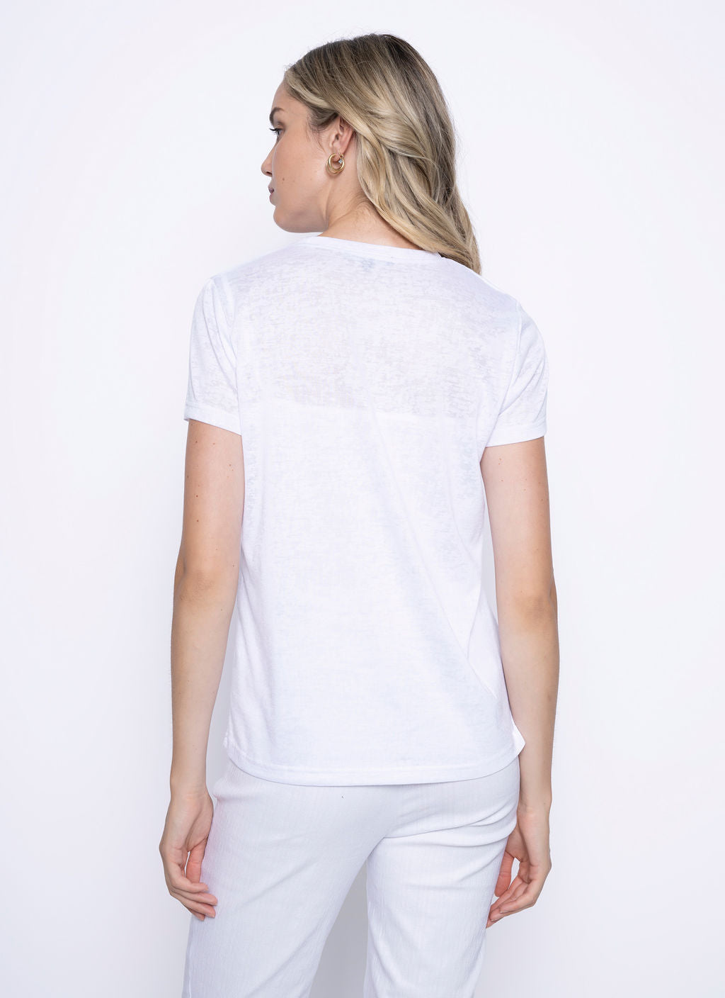 Woman wearing a white short sleeve top, viewed from the back.