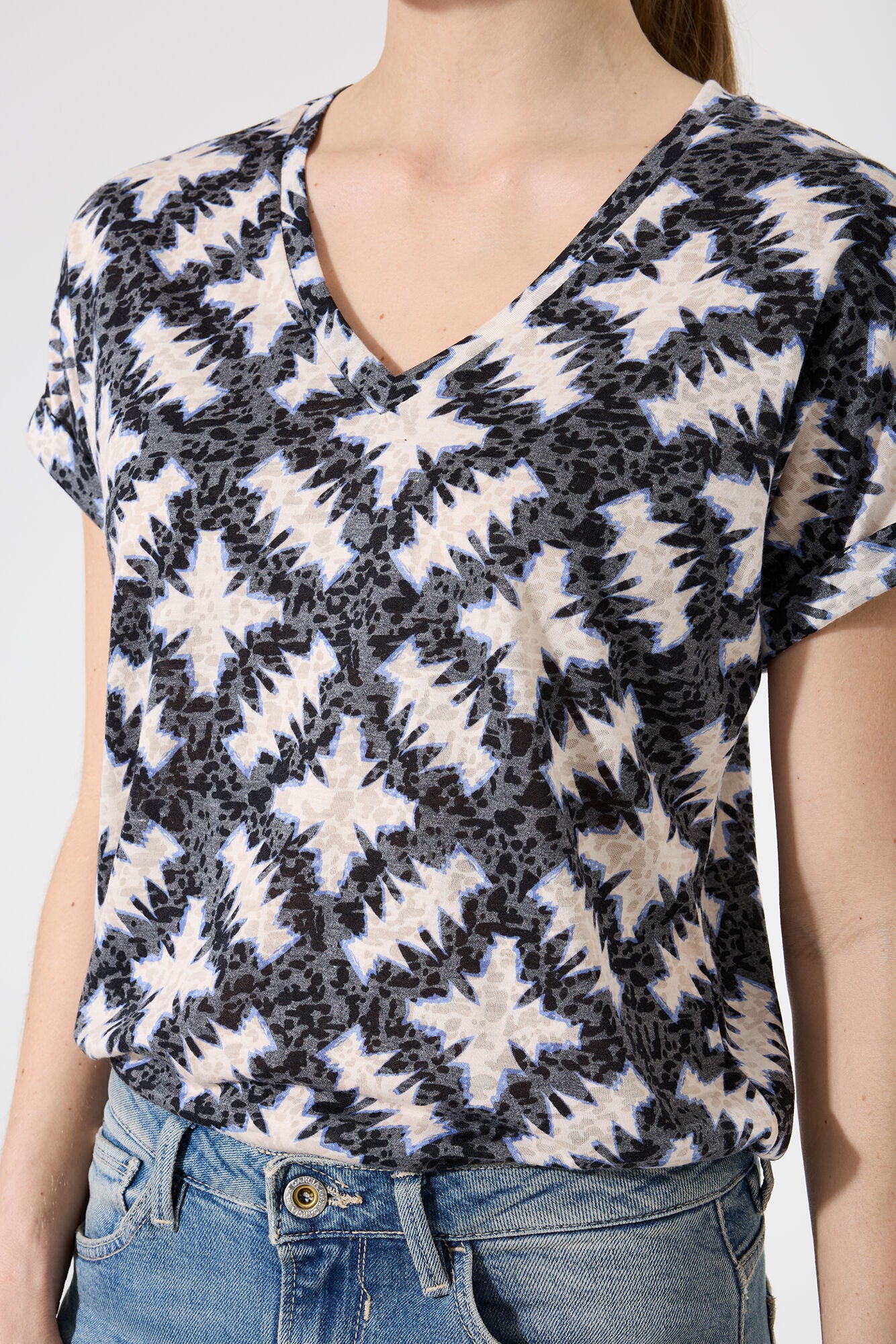 Person wearing a VNeck patterned top with a plain background