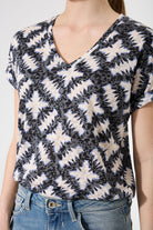 Person wearing a VNeck patterned top with a plain background