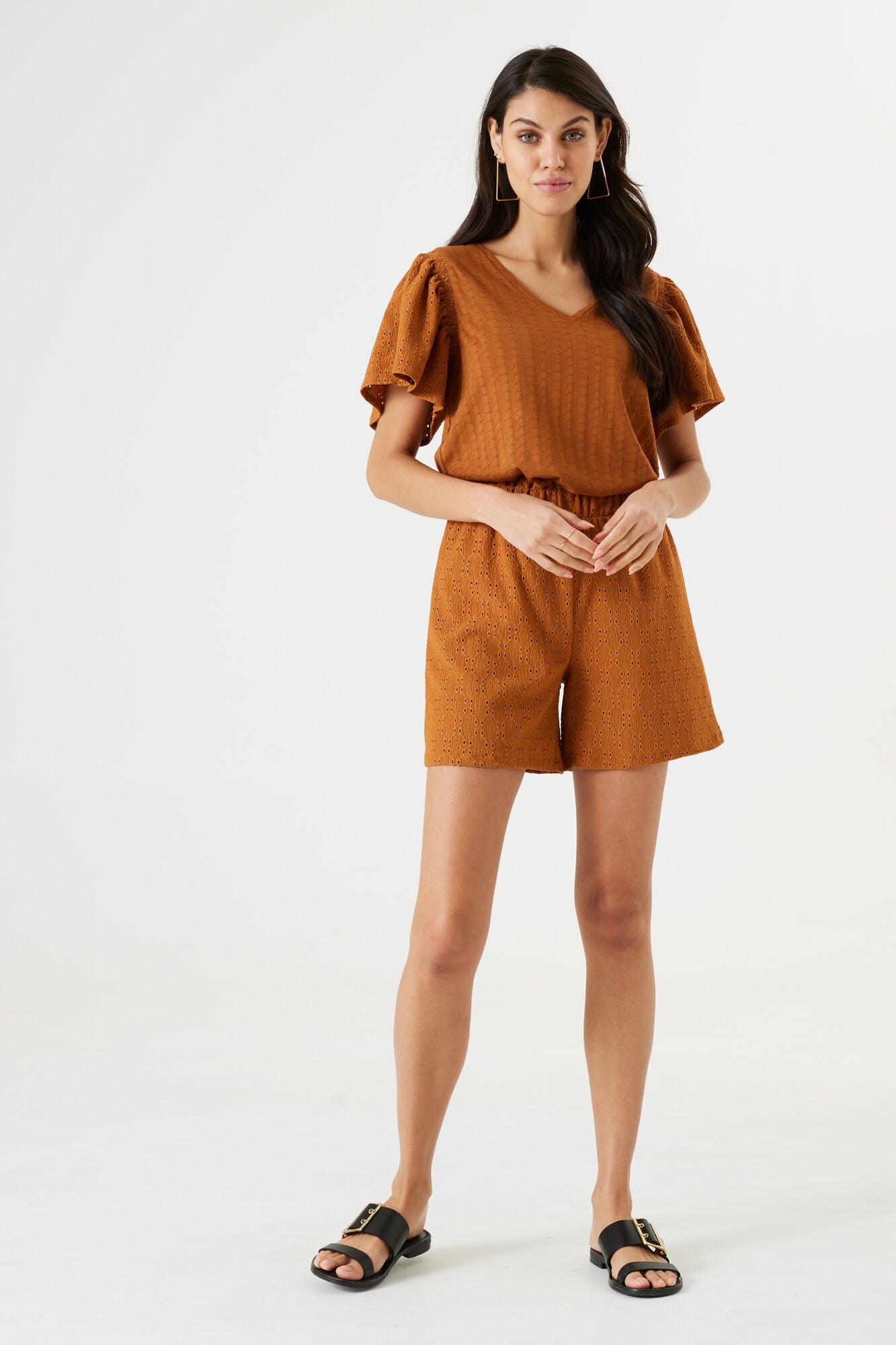 Front view of the full outfit worn by a woman – Top styled with coordinating shorts and flat sandals, captured in a natural stance.